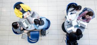 Aerial view of students working on laptops at two separate desks
